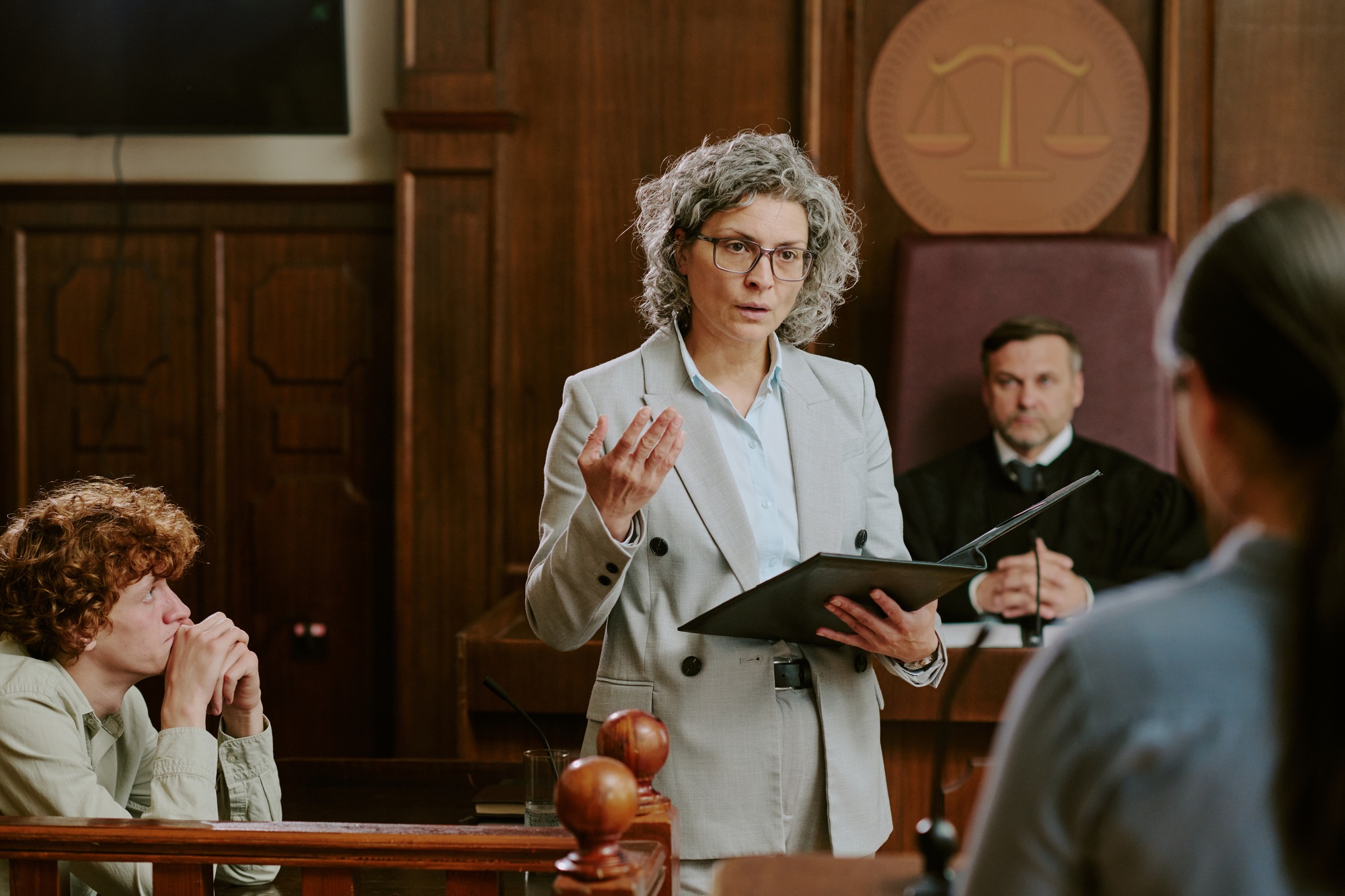Middle Aged Caucasian Woman Lawyer Addressing Witness during Court Trial