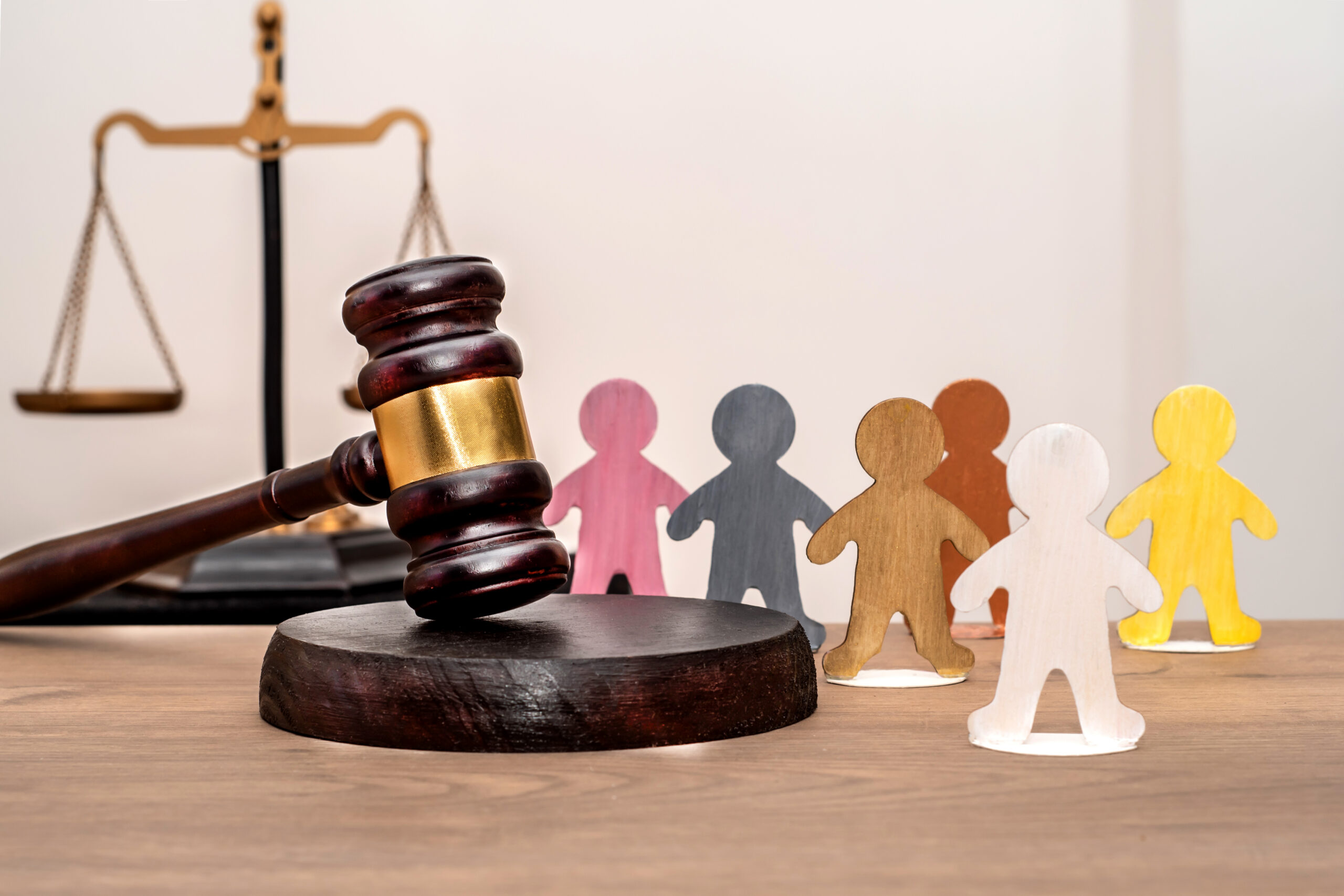 Judge's gavel, various human figures against a backdrop of the scales of justice