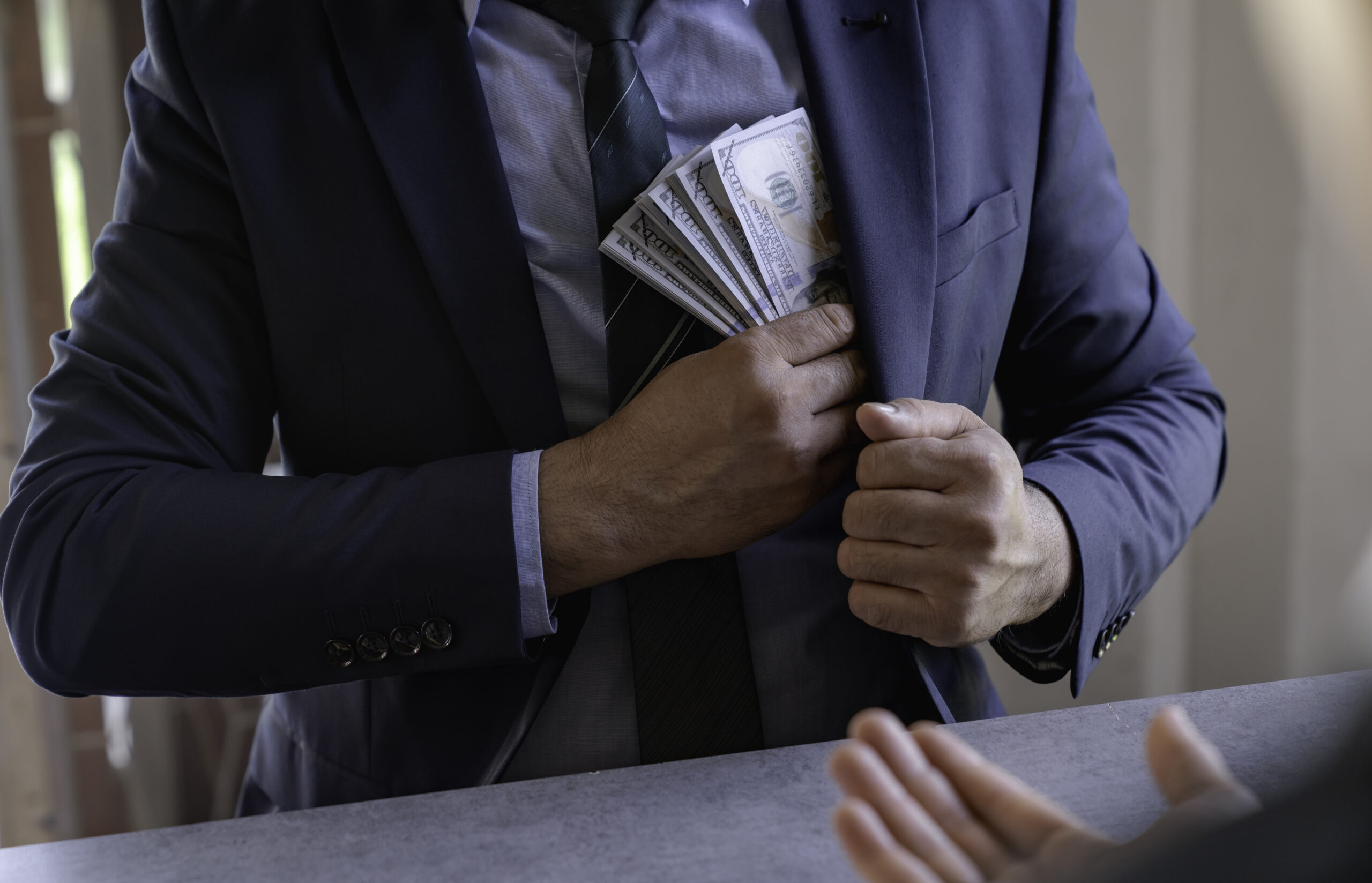 businessman or corrupt politician is offering bribes that are given in the form of dollar cash To do illegal business, corruption in the contracting business, corruption concept and bribery.